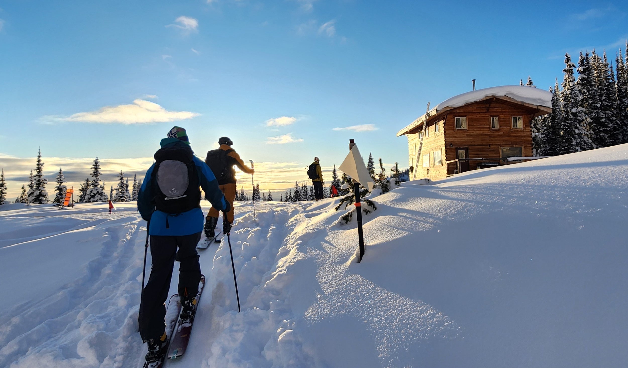 Backcountry skiers returning to Valkyr Lodge at the end of a great day of skiing Naumalten Mountain