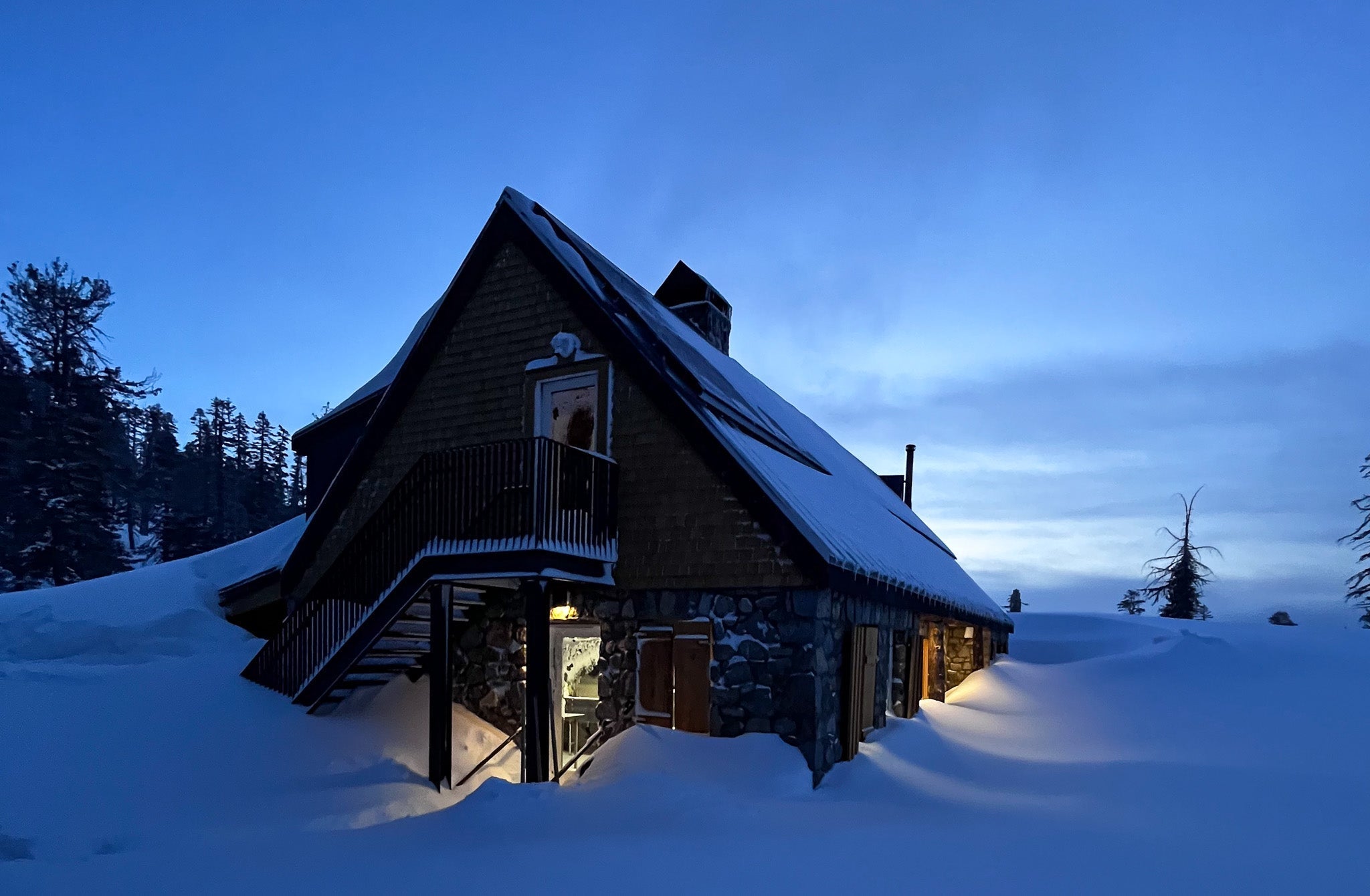 Guided backcountry skiing at the Frog lake Huts in Truckee with snow piled high on the Eschenbach House