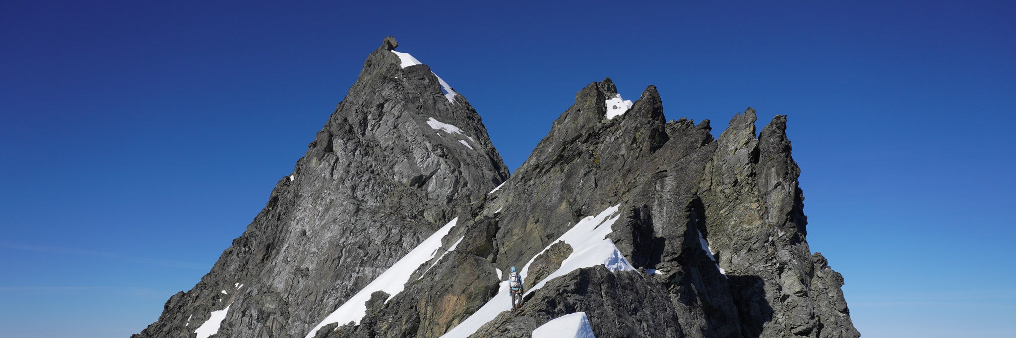 A climber traverses across exposed terrain near the summit of Mount Shuksan via the Northeast Ridge.