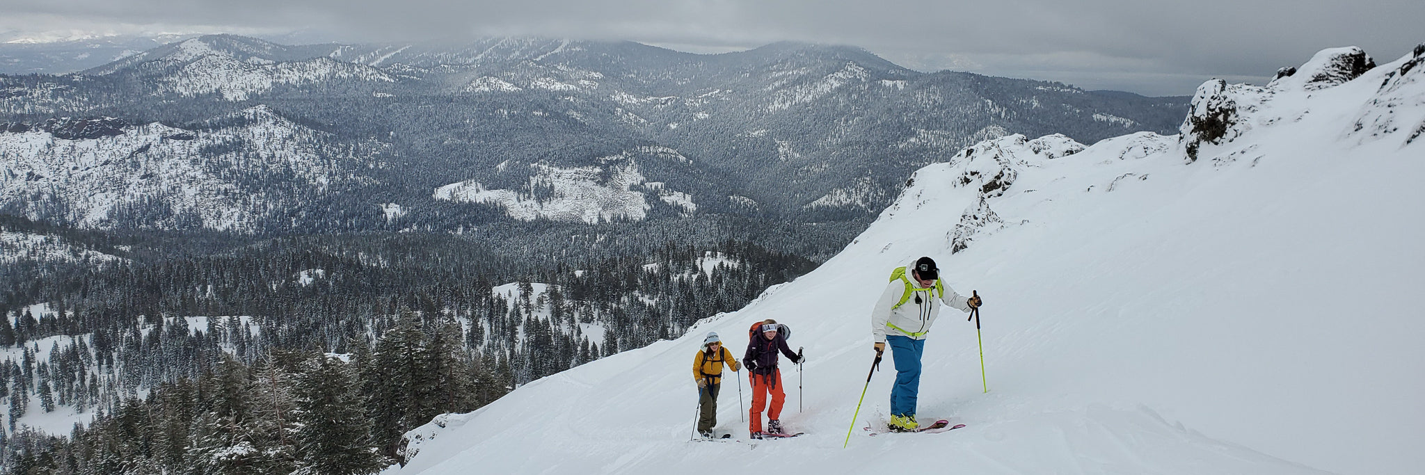 Skiers touring up a mountain during a Blackbird Guides Intro to Backcountry Course in North Lake Tahoe