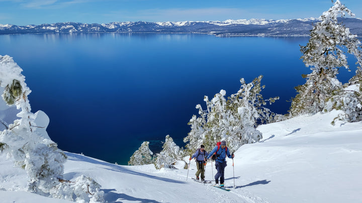 Skiers touring above lake tahoe on a bluebird day