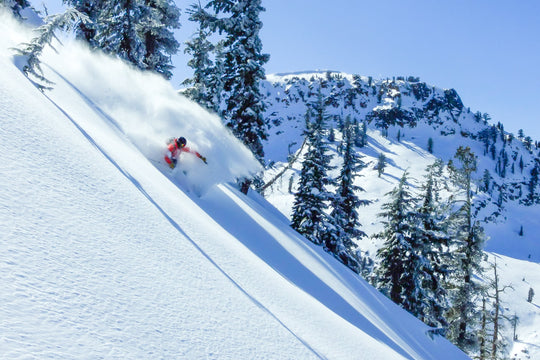 Skier making a pow turn on a sunny slope on Mt Baker in Washington